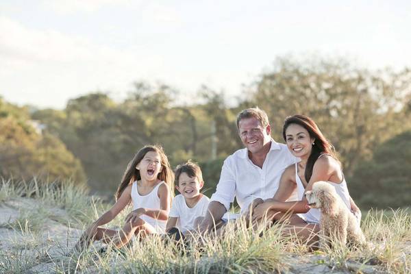 Familie mit Kindern sitzt auf Wiese