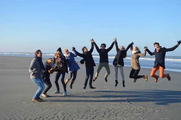 Gruppe junger Leute springt am Meer nach oben