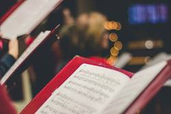 Quelle: unsplash.com / David Beale, https://unsplash.com/de/fotos/foto-der-partitur-gOsGgt4olNs Notenblatt in der Kirche