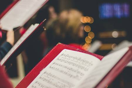 Quelle: unsplash.com / David Beale, https://unsplash.com/de/fotos/foto-der-partitur-gOsGgt4olNs Notenblatt in der Kirche